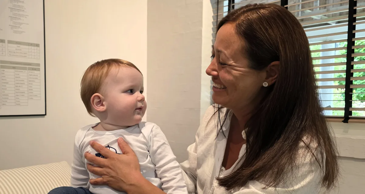 Lisbeth Kilime smiler til en tilfreds baby efter en behandling